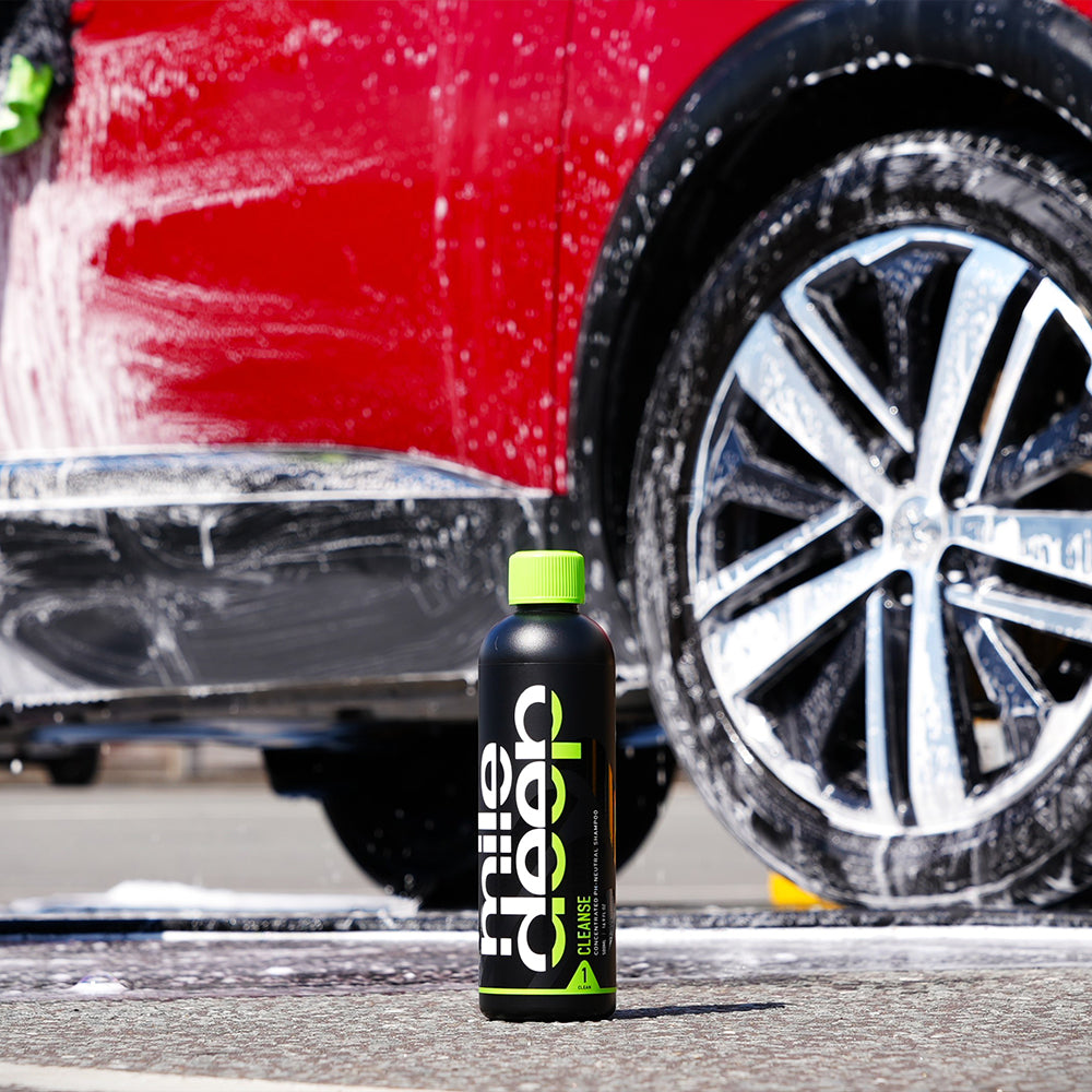 cleanse concentrated ph-neutral car shampoo placed in front of red car